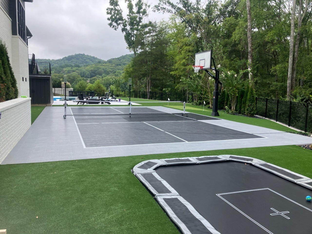 Outdoor pickleball court and in-ground trampoline.
