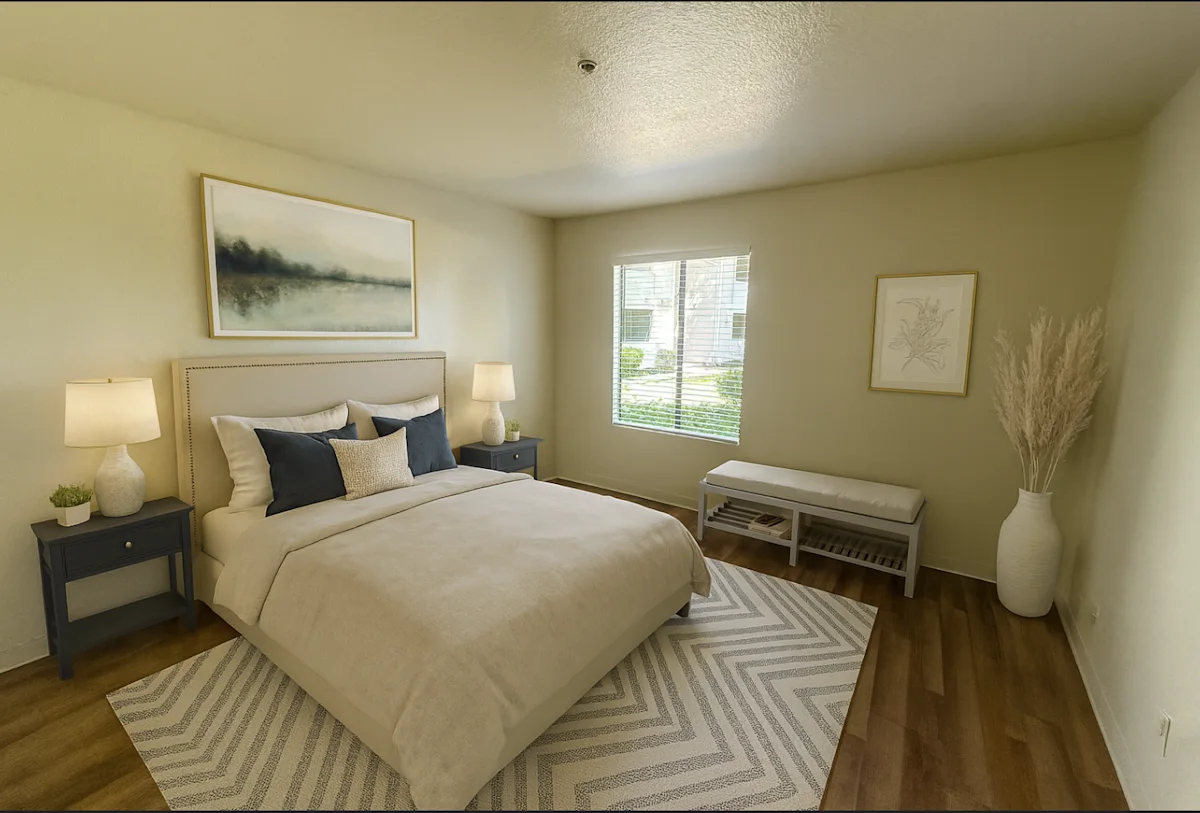 A bedroom with a large bed and a bench.