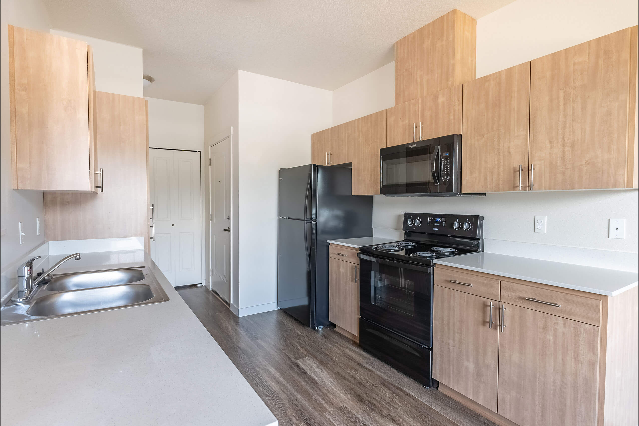 A kitchen with wooden cabinets and black appliances.