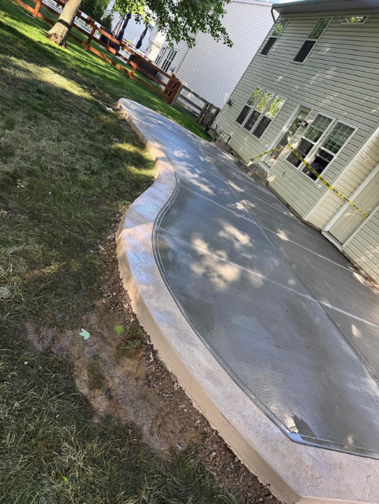 We built this stamped concrete patio for a home in Amelia, Ohio last season. It features easy, curved lines and a broom finish on the surface. The border really makes it pop, though. We used a stamp to make it look like stone. Do you want to transform your backyard? Call us for a FREE estimate. We'll come to you.