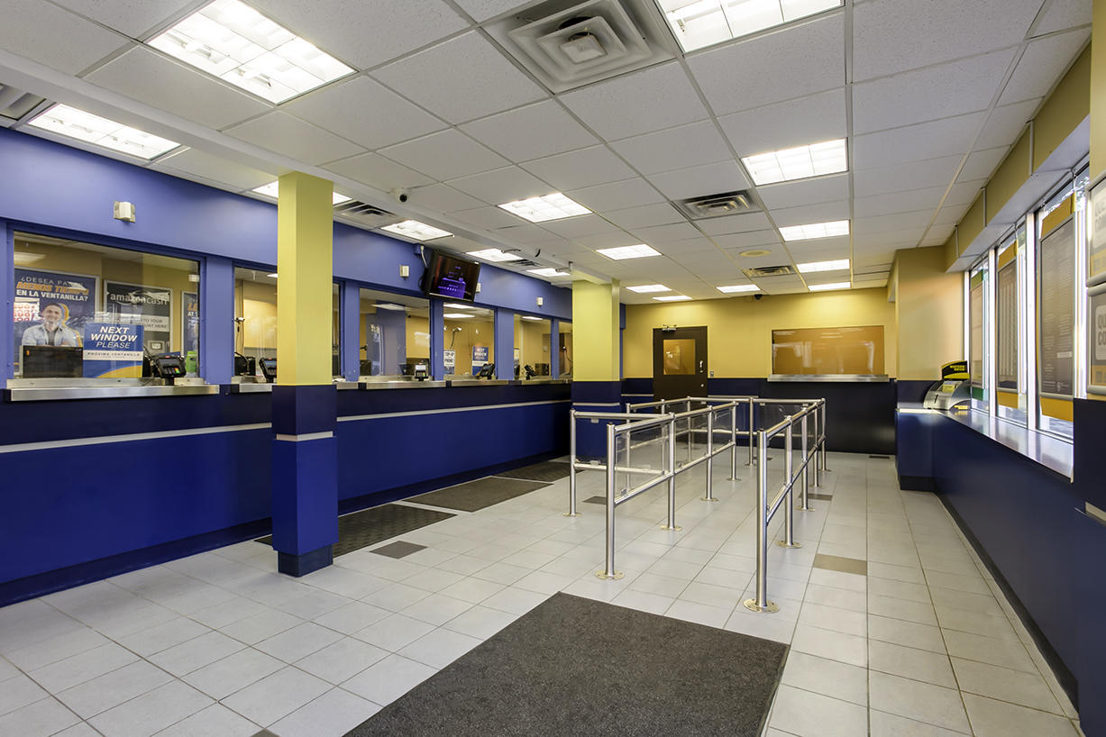Customer waiting area and teller windows inside PAYOMATIC store located at 271 East 149th St Bronx, NY 10451