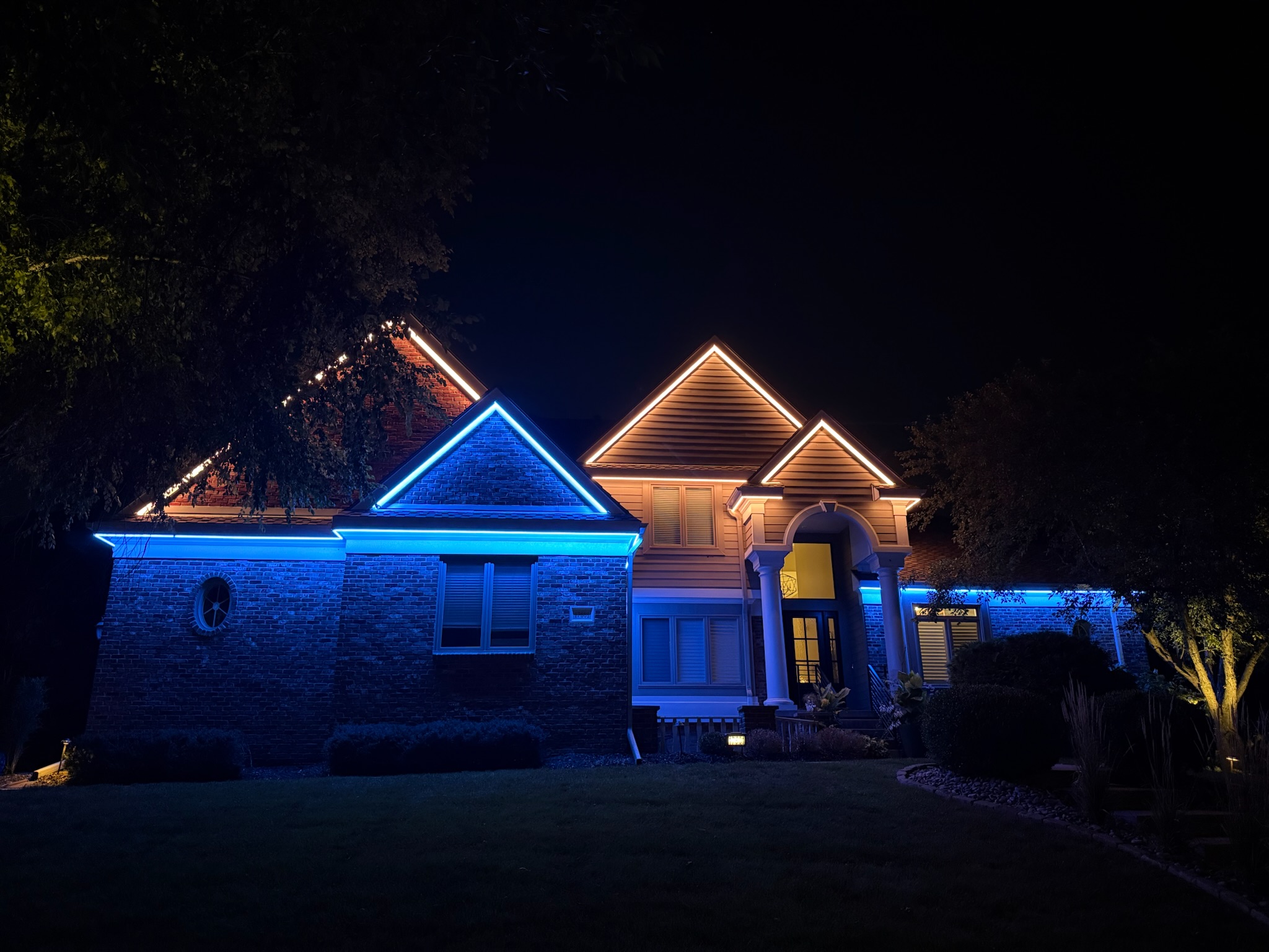 Blue exterior accent lighting highlighting the roofline and front facade of a home.