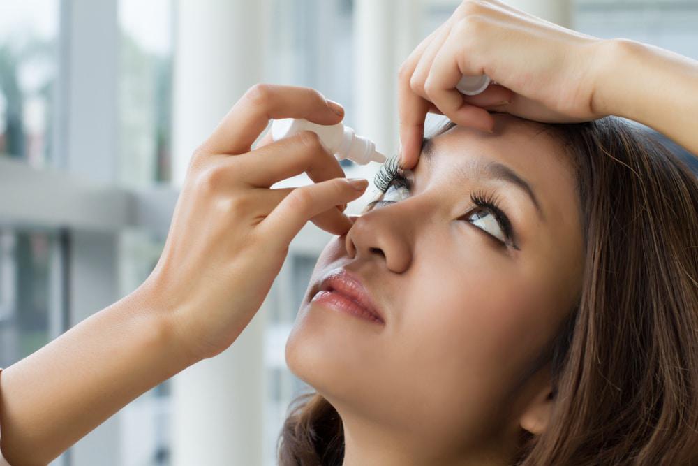 woman putting eye drops in eyes