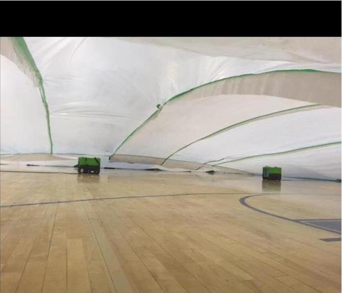 SERVPRO demonstrates an unique way of drying a gym floor at a local Youth Center.  The results were successful. SERVPRO uses an unconventional method to control the humidity levels in the vast area.
