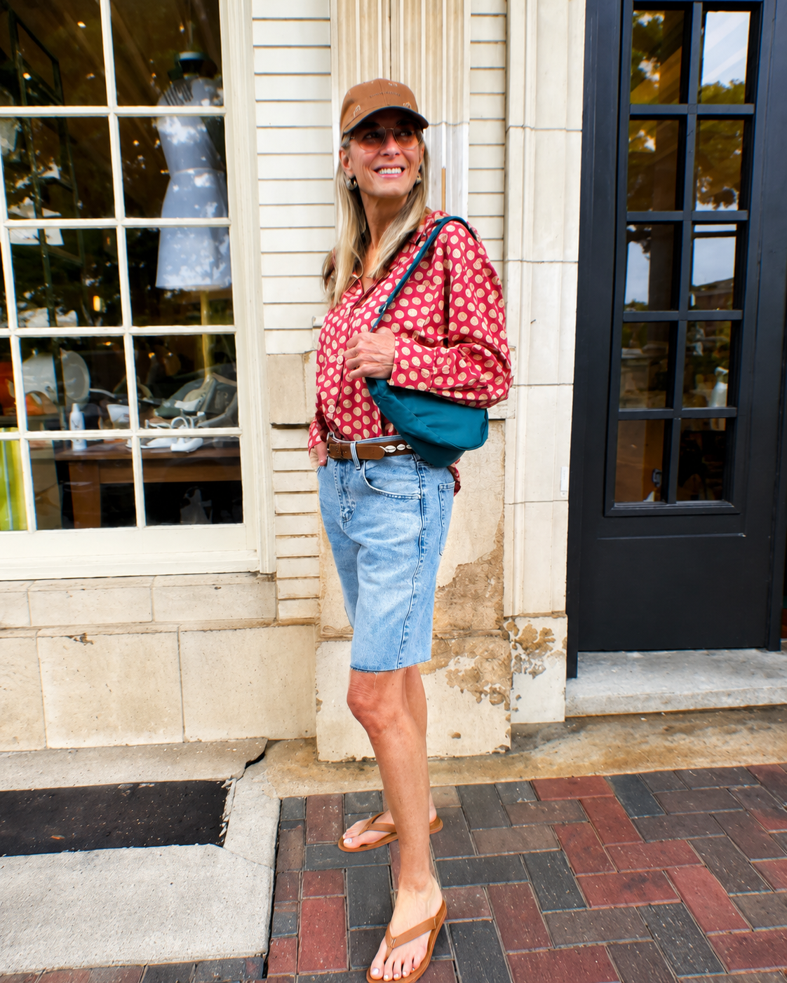 Fashion-forward women's clothing and accessories displayed in a lifestyle setting, featuring casual wear, denim shorts, handbags, and seasonal boutique fashion.