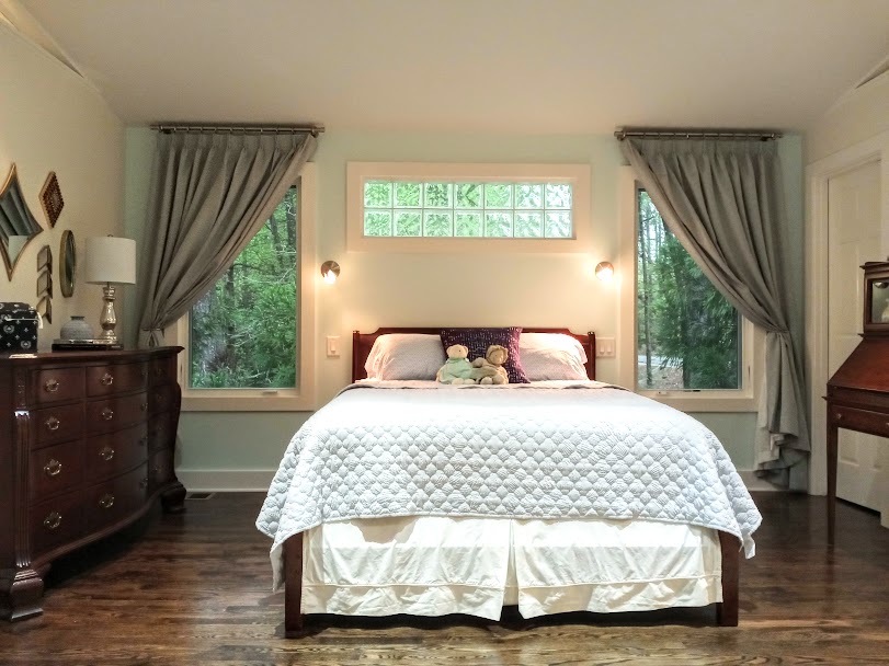 Double wide drapery panels were used to create an elegant look for this bedroom. Hold-backs allow the drapery to be pulled back from the window to let in natural light. When closed they completely cover the window and block out light for a restful sleep.