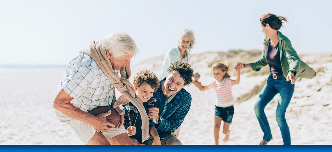 A multigenerational family playing together on a beach.