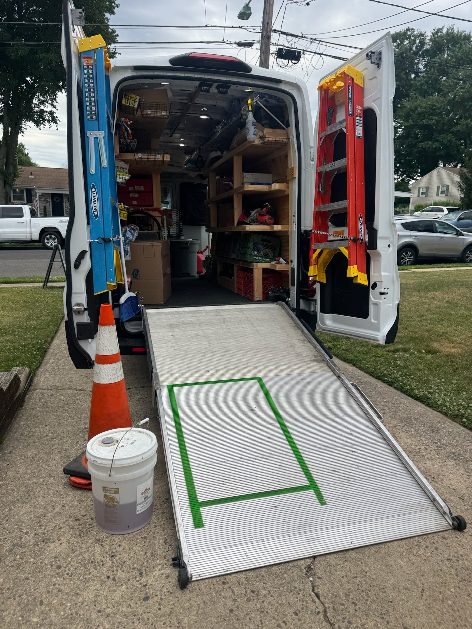 Brick Asbestos & Demolition service van parked at a residential job site with equipment visible inside, ready for asbestos removal or demolition work.