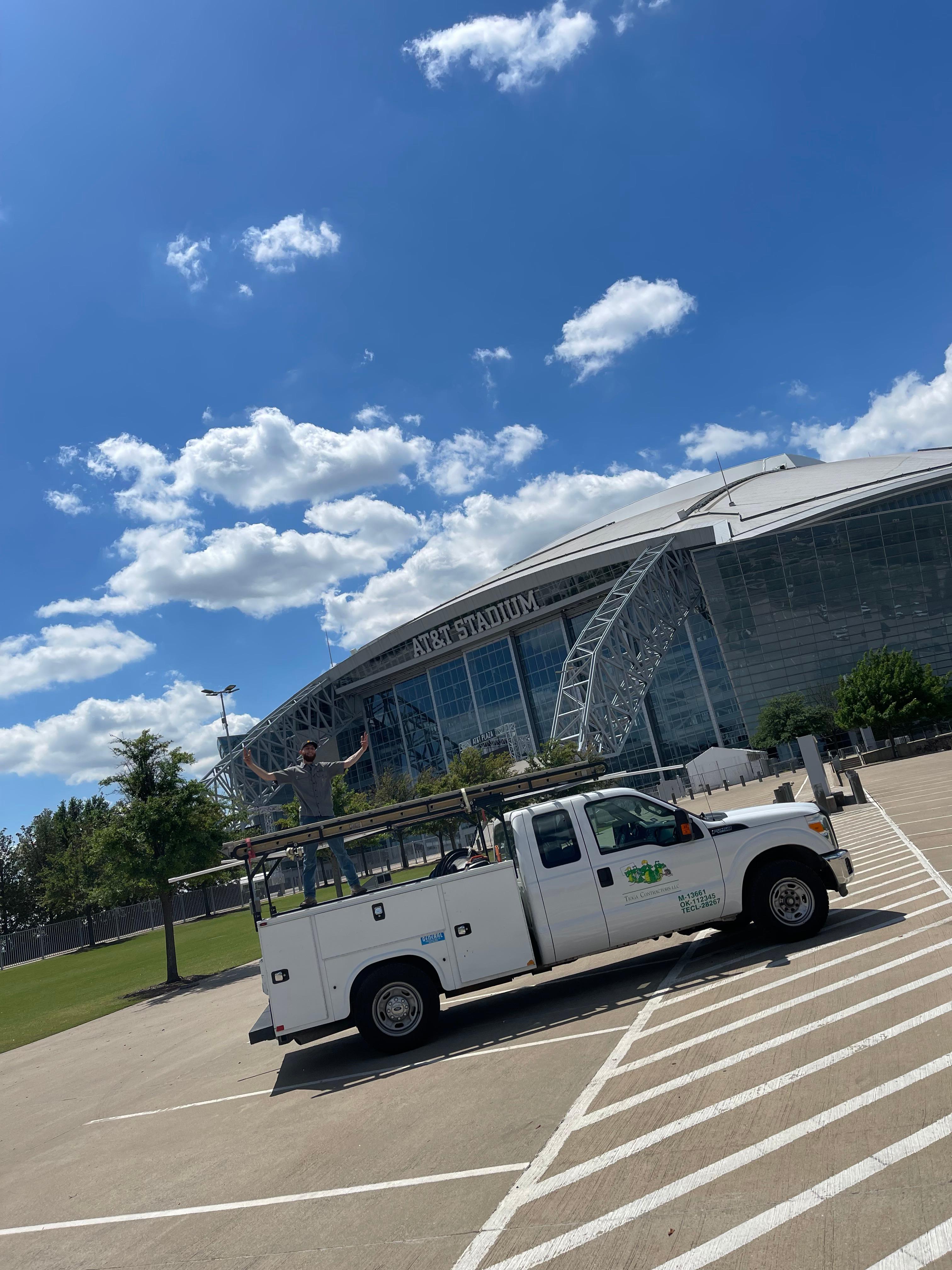 A Tioga Plumbing & Electric tech with his truck at the AT&T Stadium in Arlington Texas.