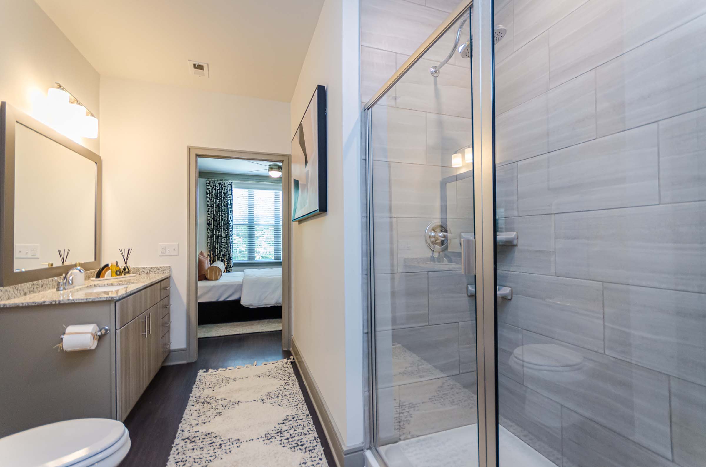 Glass enclosed walk in shower with dual sink vanity in the primary bath at Camden Alpharetta apartments in Alpharetta, GA.