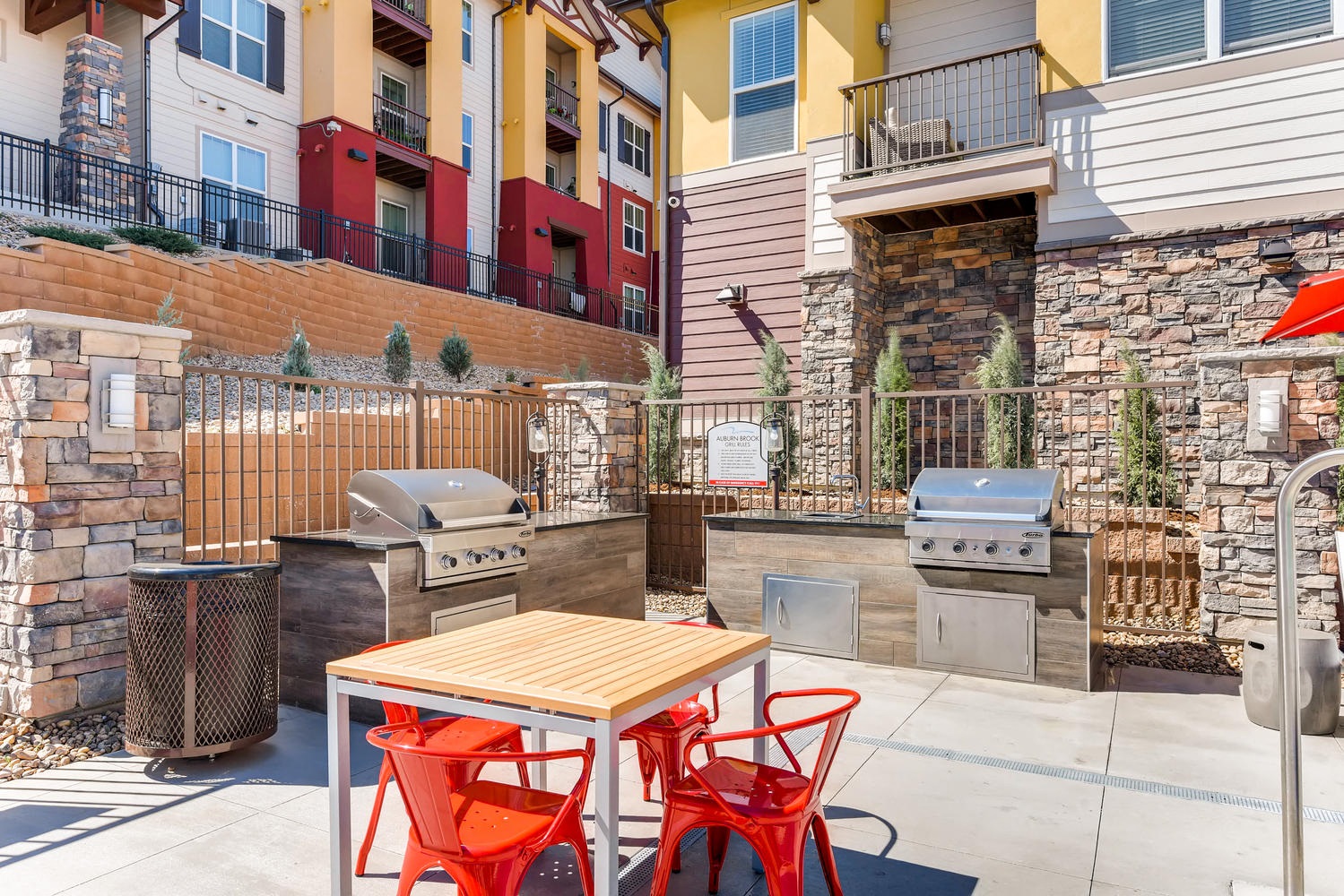 A patio with a table and chairs and a grill.
