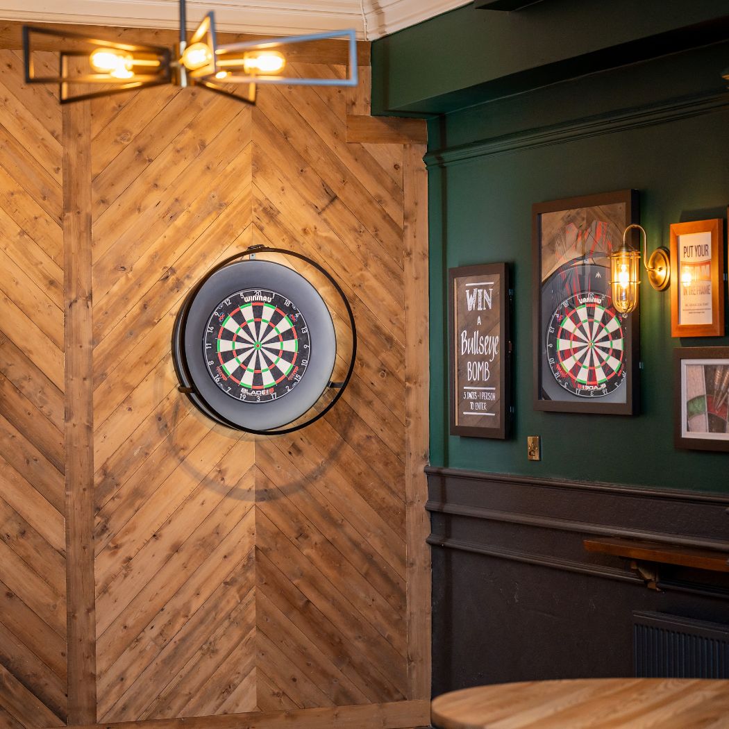 Modern darts setup with wooden panelled backdrop and feature lighting, ideal for social games.