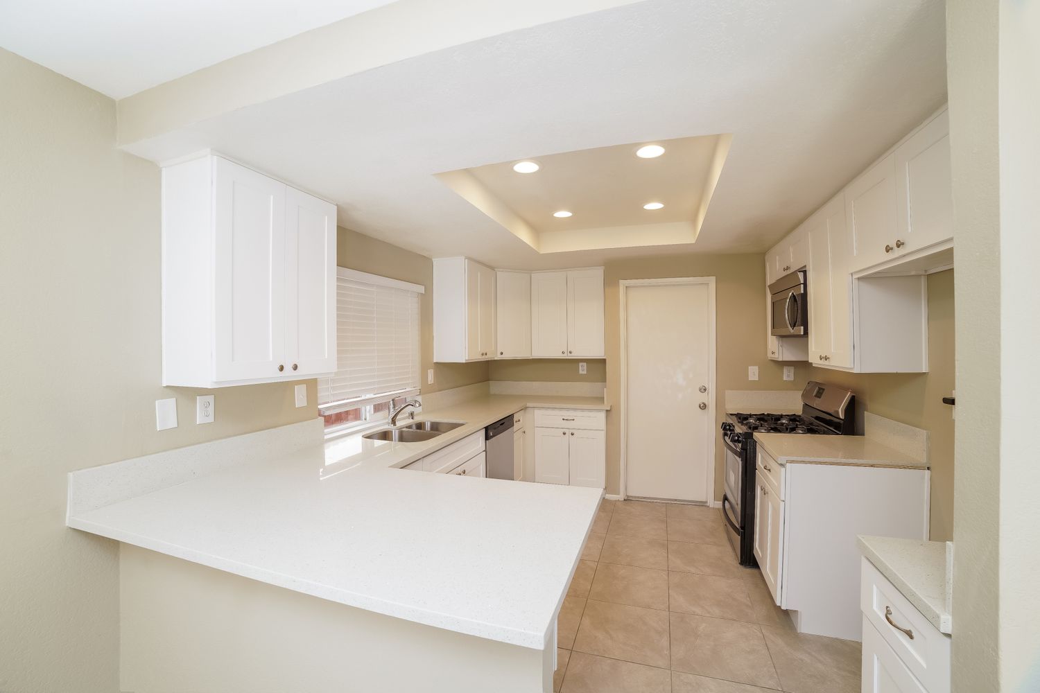 Kitchen with peninsula and stainless steel appliances at Invitation Homes Southern California.