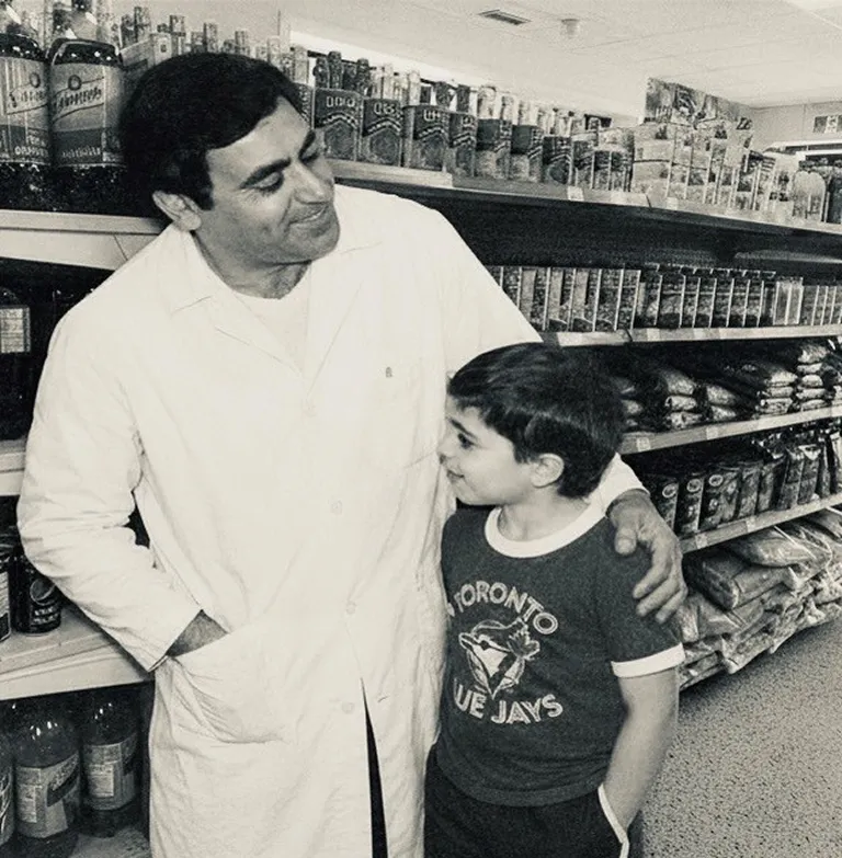 A black and white photo of Anthony Galluzzo and his father at their family store.