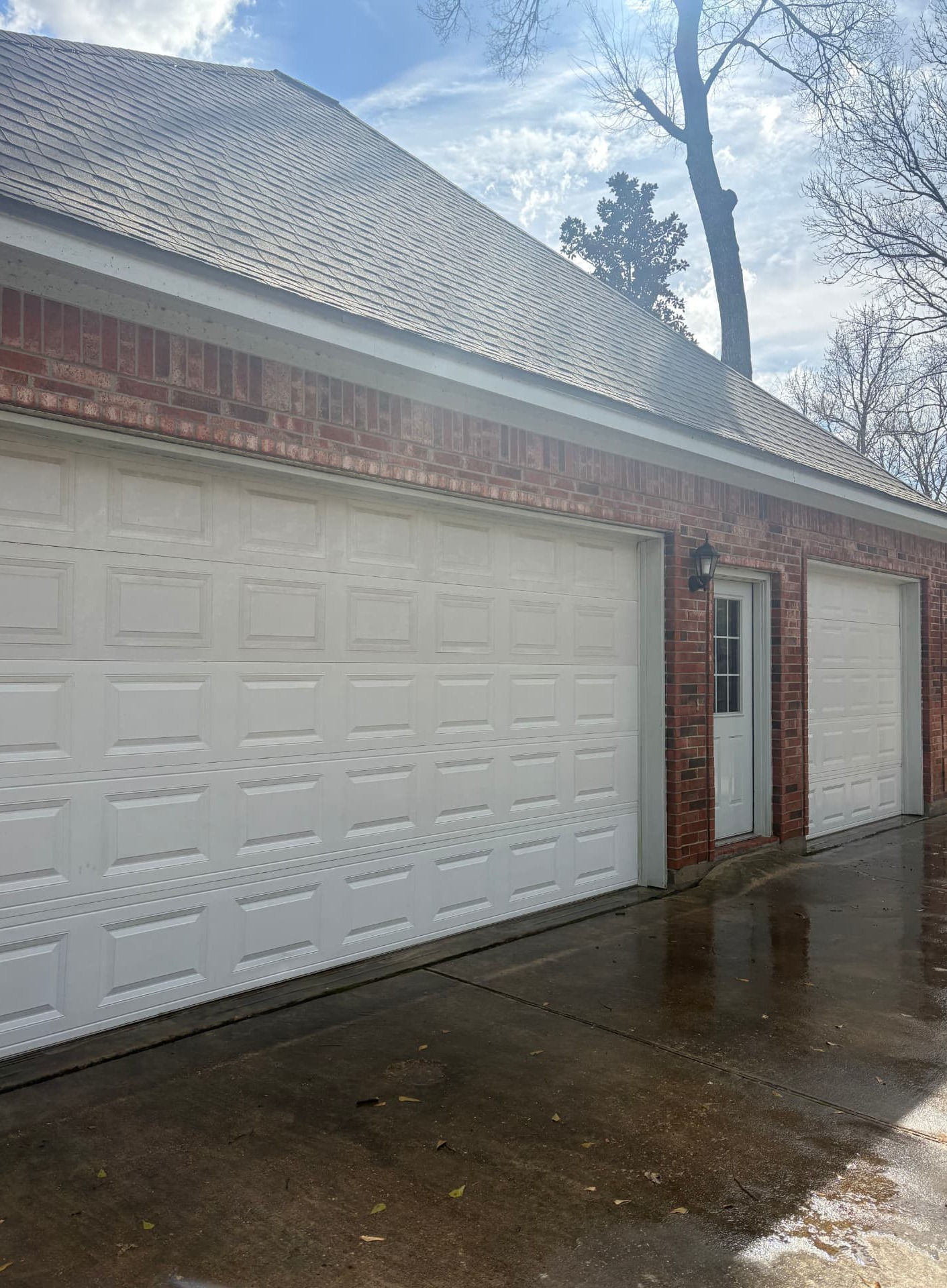 Professionally cleaned garage door with dirt, grime, and buildup removed, showcasing exterior cleaning and pressure washing services in Conroe, TX by Integrative Soft Wash and Property Services