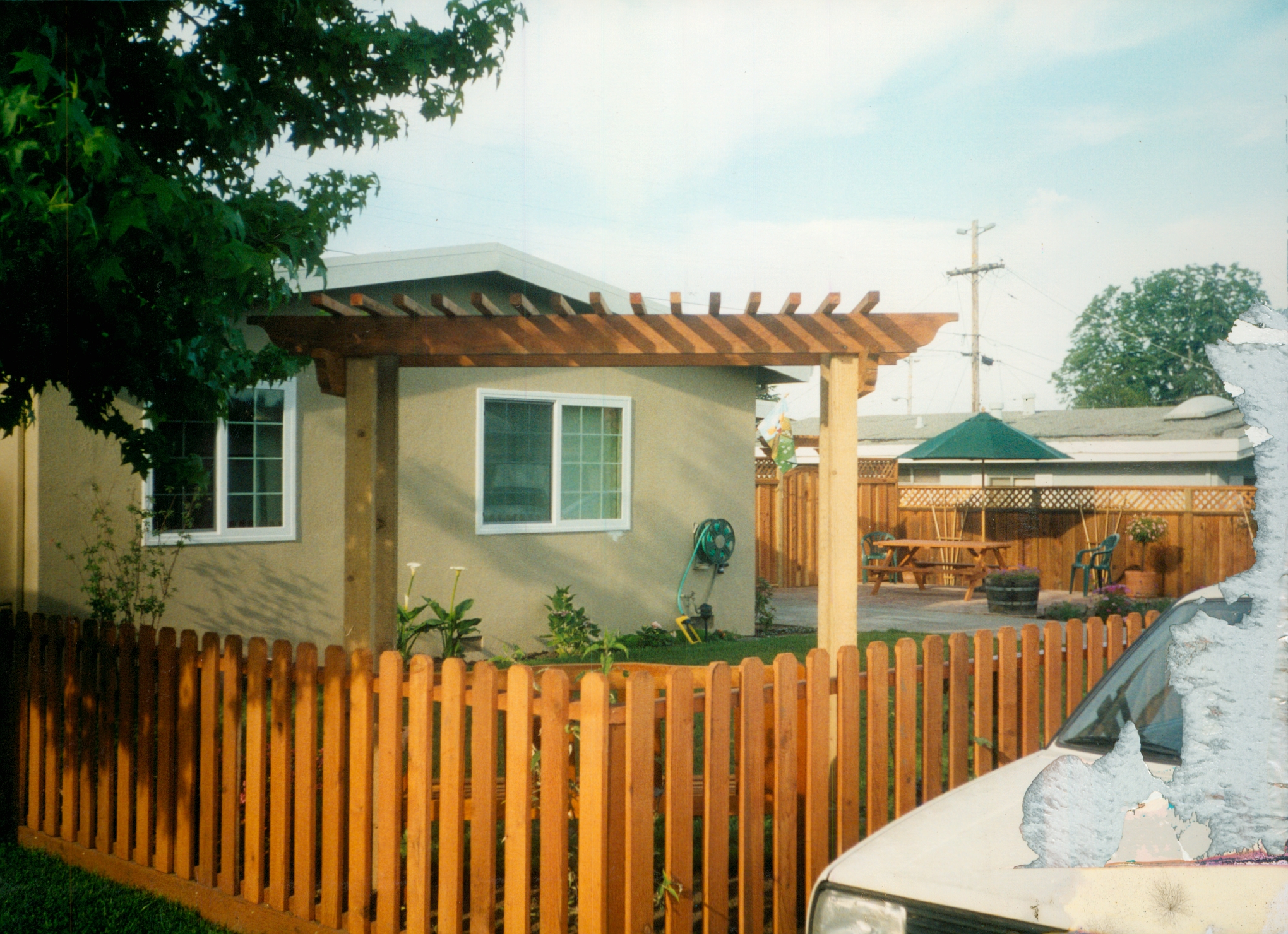 Wood picket fence installed around a residential front yard, adding charm, security, and curb appeal.