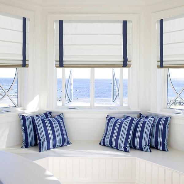 These blue, banded Roman shades provide a pop of color that perfectly matches the throw pillows (and the view) of this cozy sitting nook. With a wide array of fabrics, styles and colors to choose from, you can be sure to find the perfect window solution for your space.