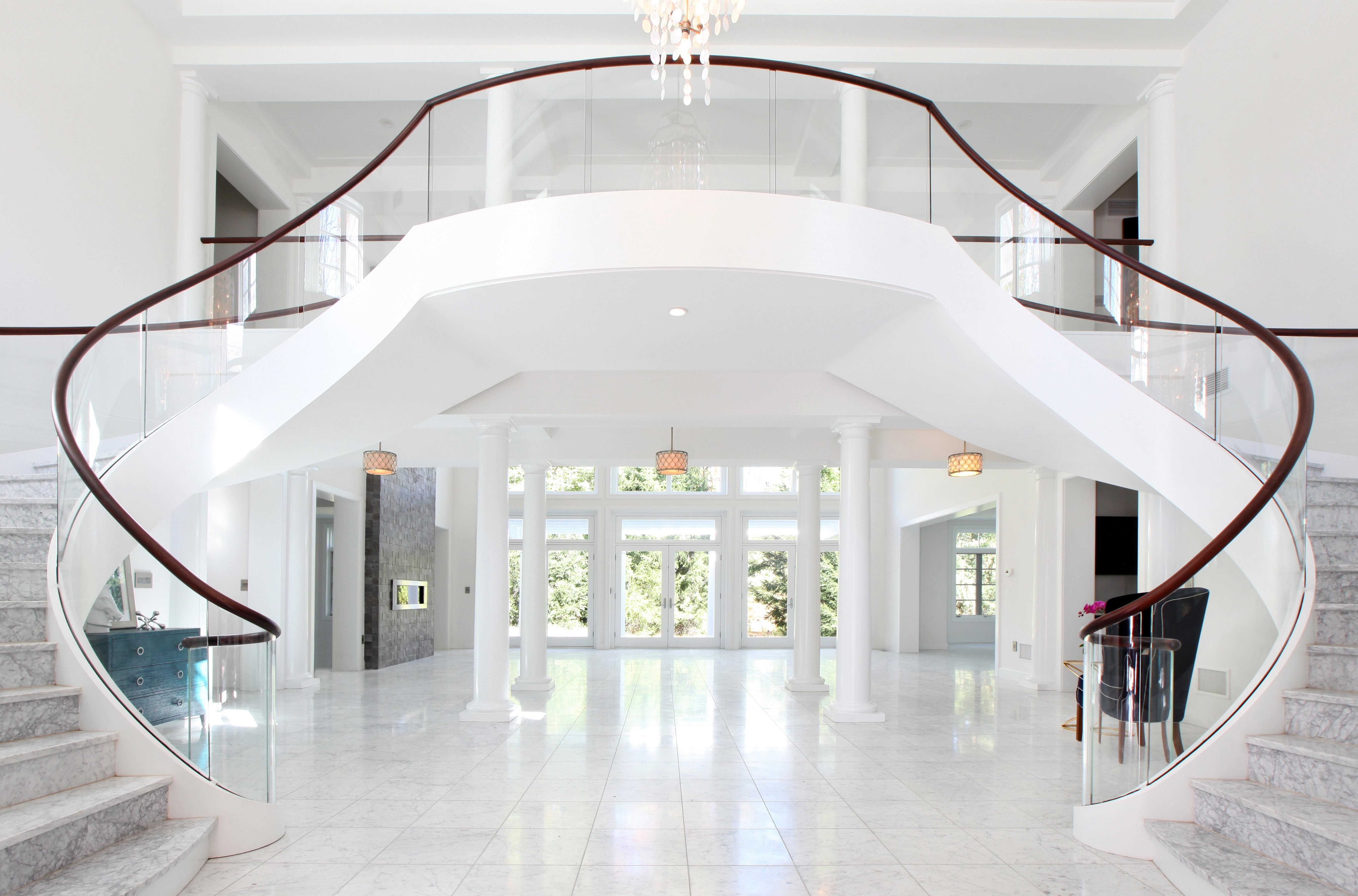 Love this grand entrance with a sweeping marble and glass staircase! Lasley Brahaney Architecture + Construction. We are your architect and contractor in Princeton, NJ. (609) 921-2822