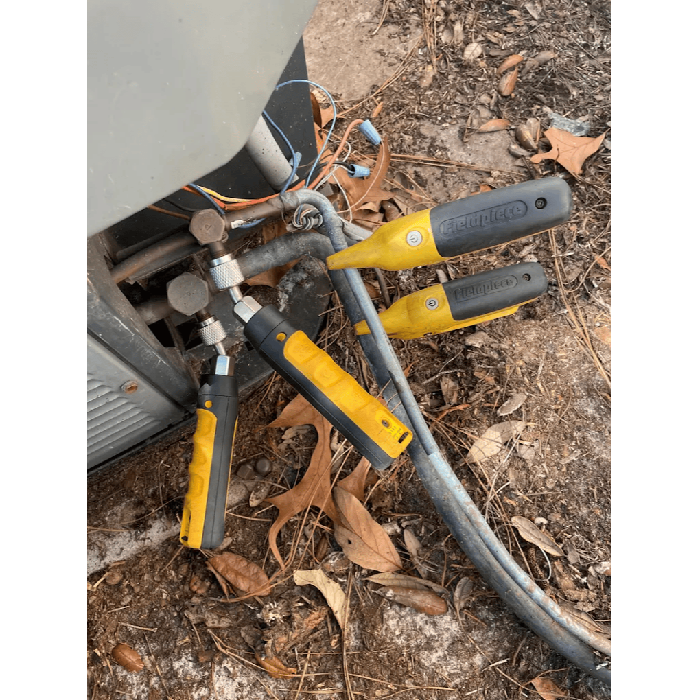 HVAC technician using leak detection tools on AC refrigerant lines for air conditioning repair by Gotcha Heating and Air Inc in Spring Hill Florida
