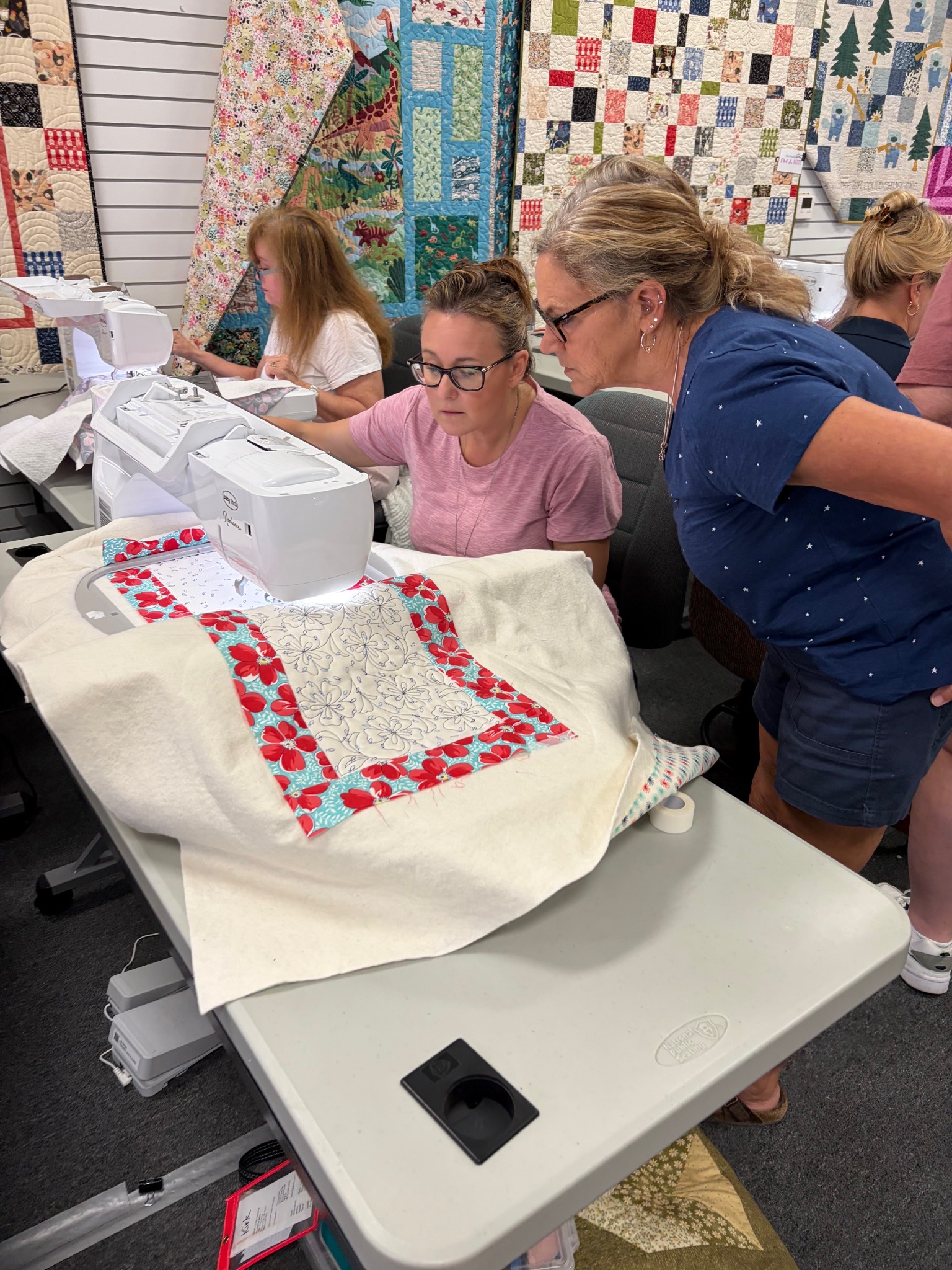 Students work together on a Decorative Stitch project, learning machine embroidery and quilting techniques with hands-on guidance. The class encourages creativity, skill building, and confidence at every stitch.