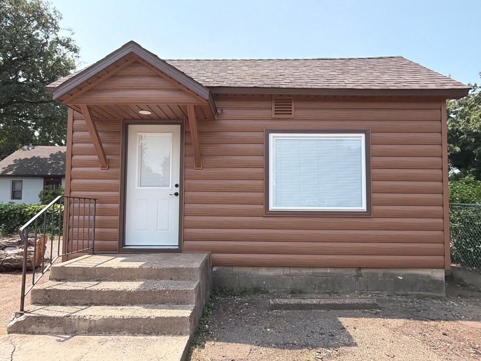 New seamless steel log-profile siding, soffit and fascia, along with new windows and doors. The woodgrain log siding completely changed the look of this little building while still giving it a rustic feel that fits its history.