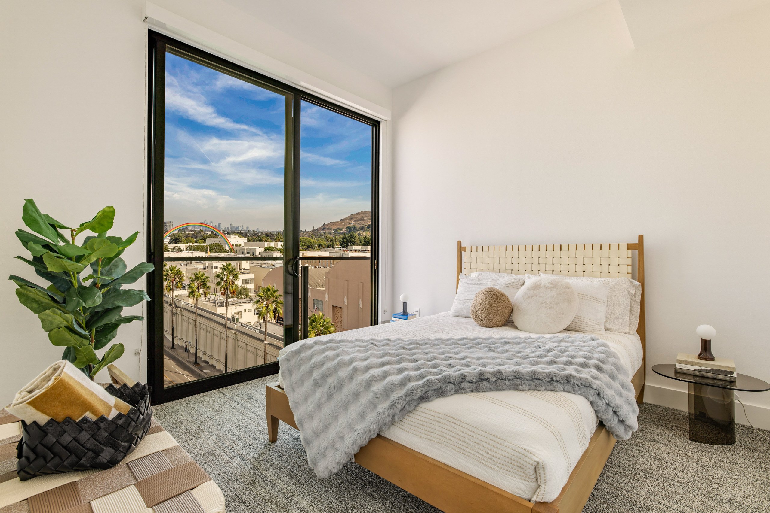 A bedroom with a large bed and a view of the city.