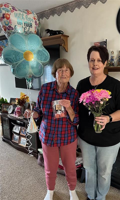 Caregiver celebrating an older adult’s birthday and supporting meaningful moments at home.