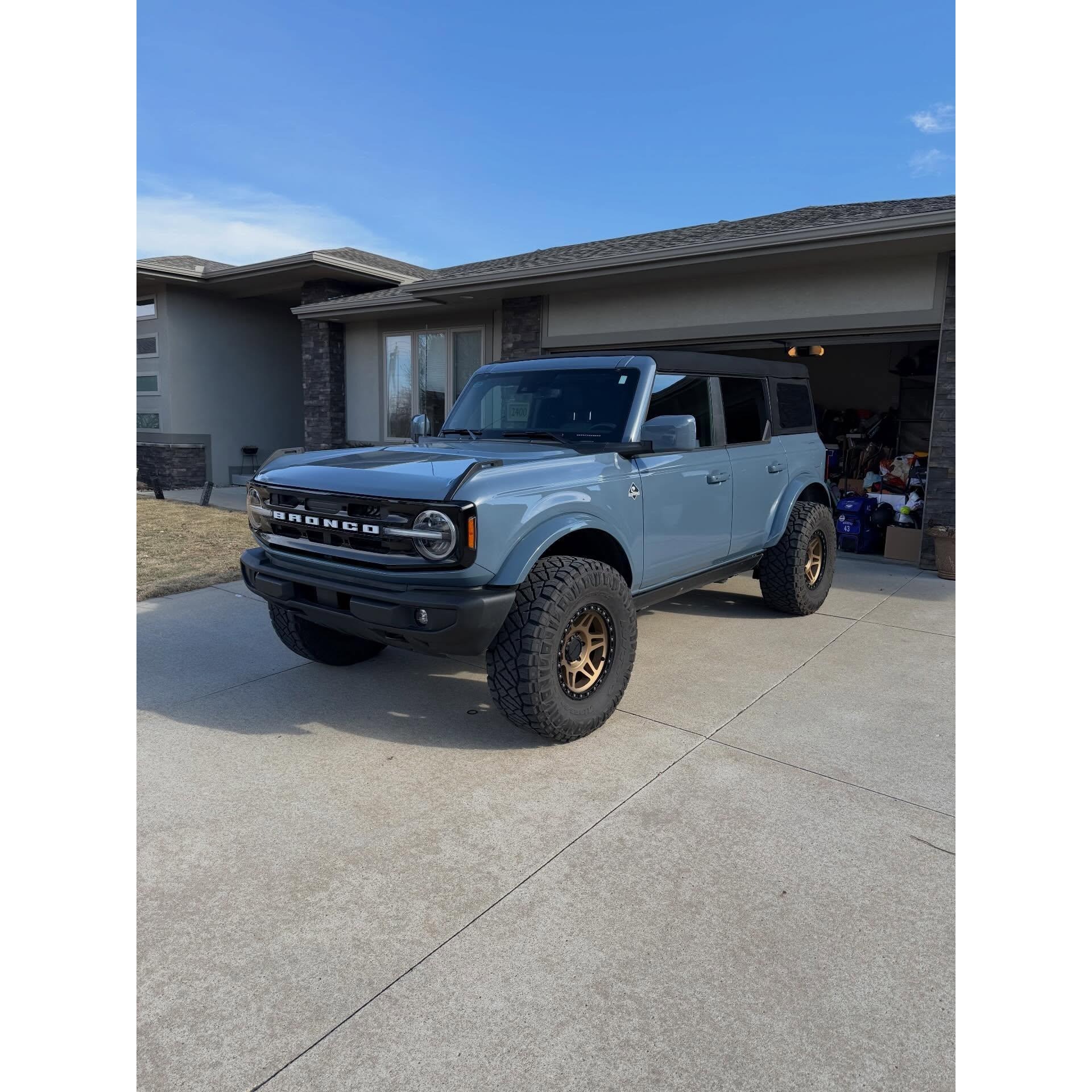Lifted blue Ford Bronco detailed at a residential driveway, highlighting exterior cleaning, wheel care, and mobile detailing for trucks and SUVs.