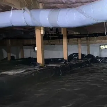 Professionally encapsulated crawl space featuring a white reinforced vapor barrier covering floors and support columns. The sealed environment helps improve indoor air quality and moisture control.
