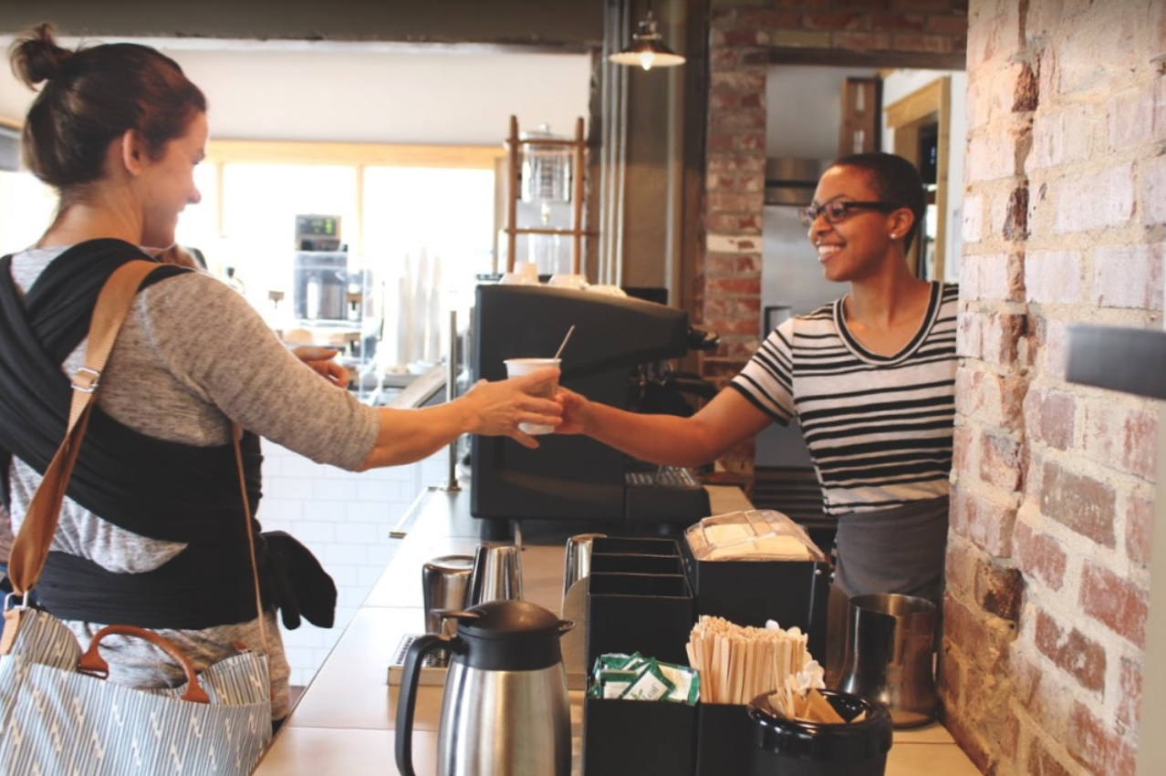 K Brew Barista serving drink to a customer