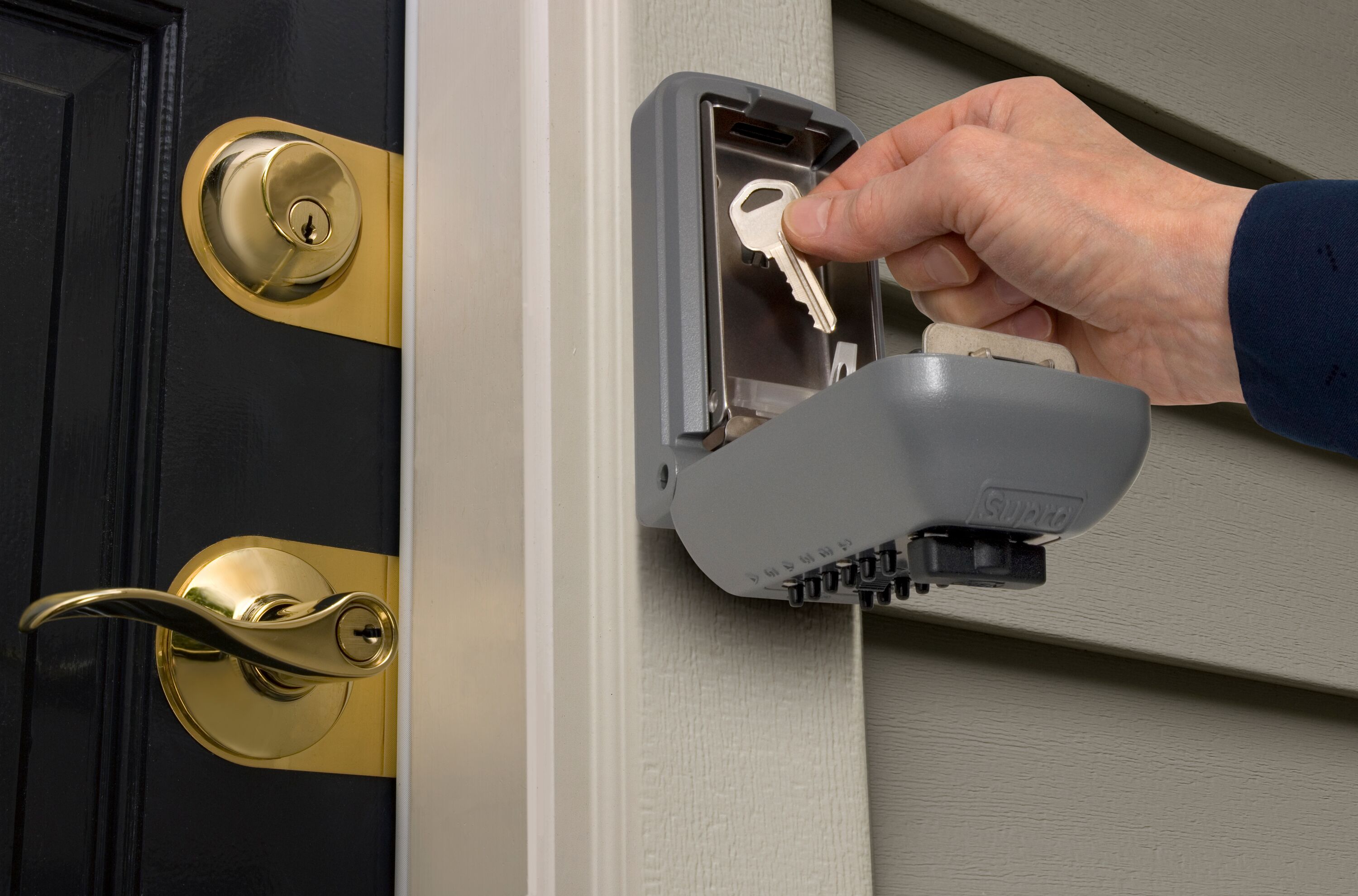 Image of a person putting a key in a key safe.