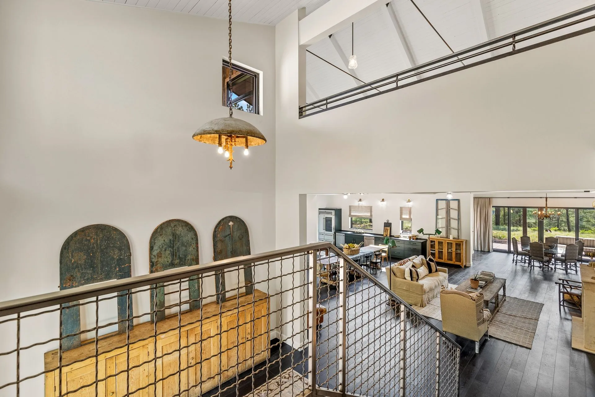 Open-concept interior showcasing high ceilings, custom railings, and connected living spaces. Designed to maximize natural light, functionality, and a spacious feel throughout the home.