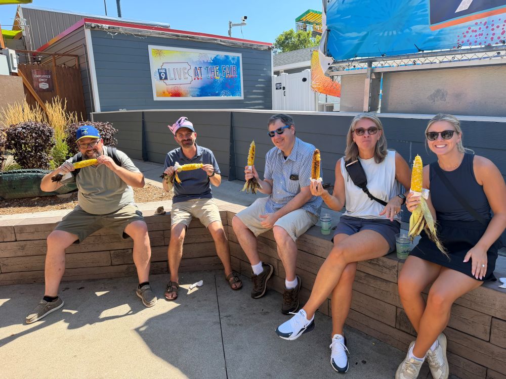 Taking a quick snack break! Members of the Clarity Financial team enjoying fresh roasted sweet corn on the cob near the Fox 9 Live at the Fair booth.