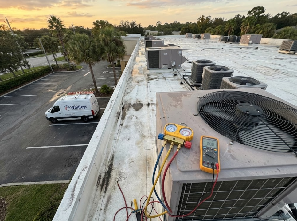 A rooftop scene shows multiple air conditioning units, some with diagnostic equipment attached. In t 