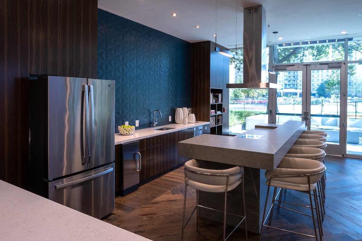 a kitchen with stainless steel appliances and a counter with bar stools
