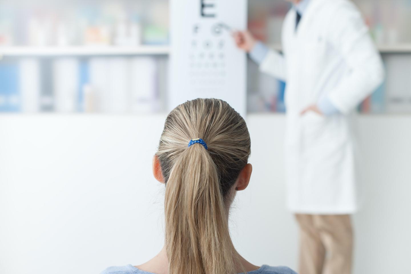 Optometrist giving patient an eye exam.