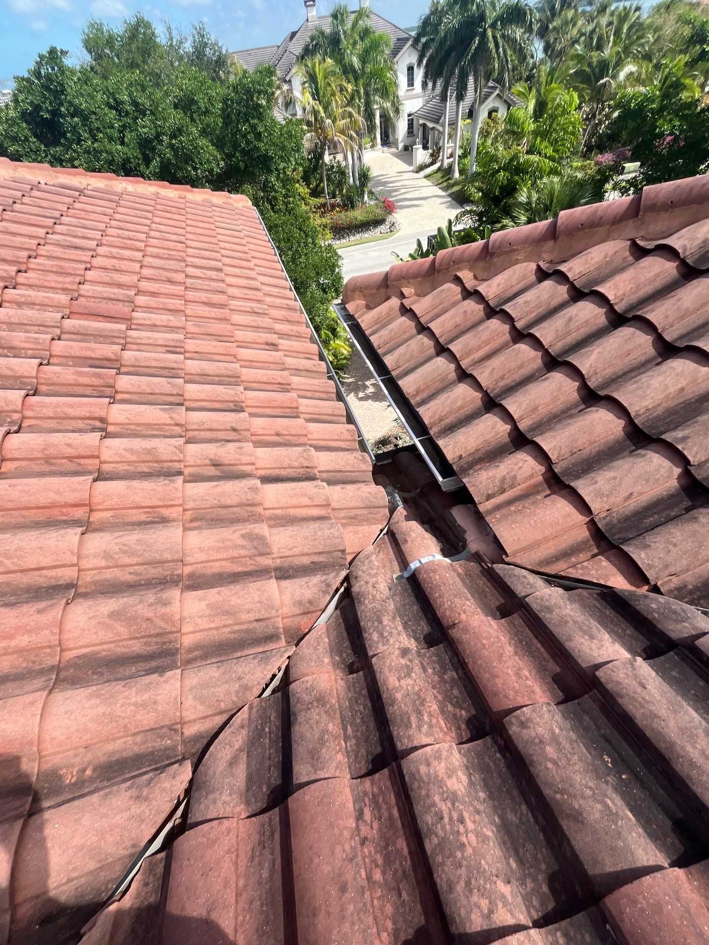 Close-up view of a clay tile roof showing the roof valley and ridge area, highlighting the style and 