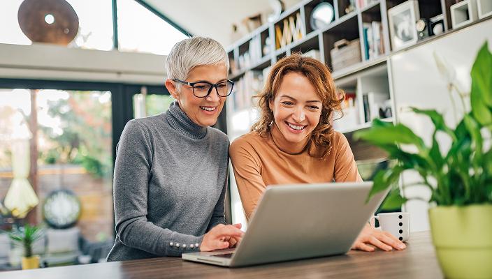 Two women reviewing their investments at their laptop.