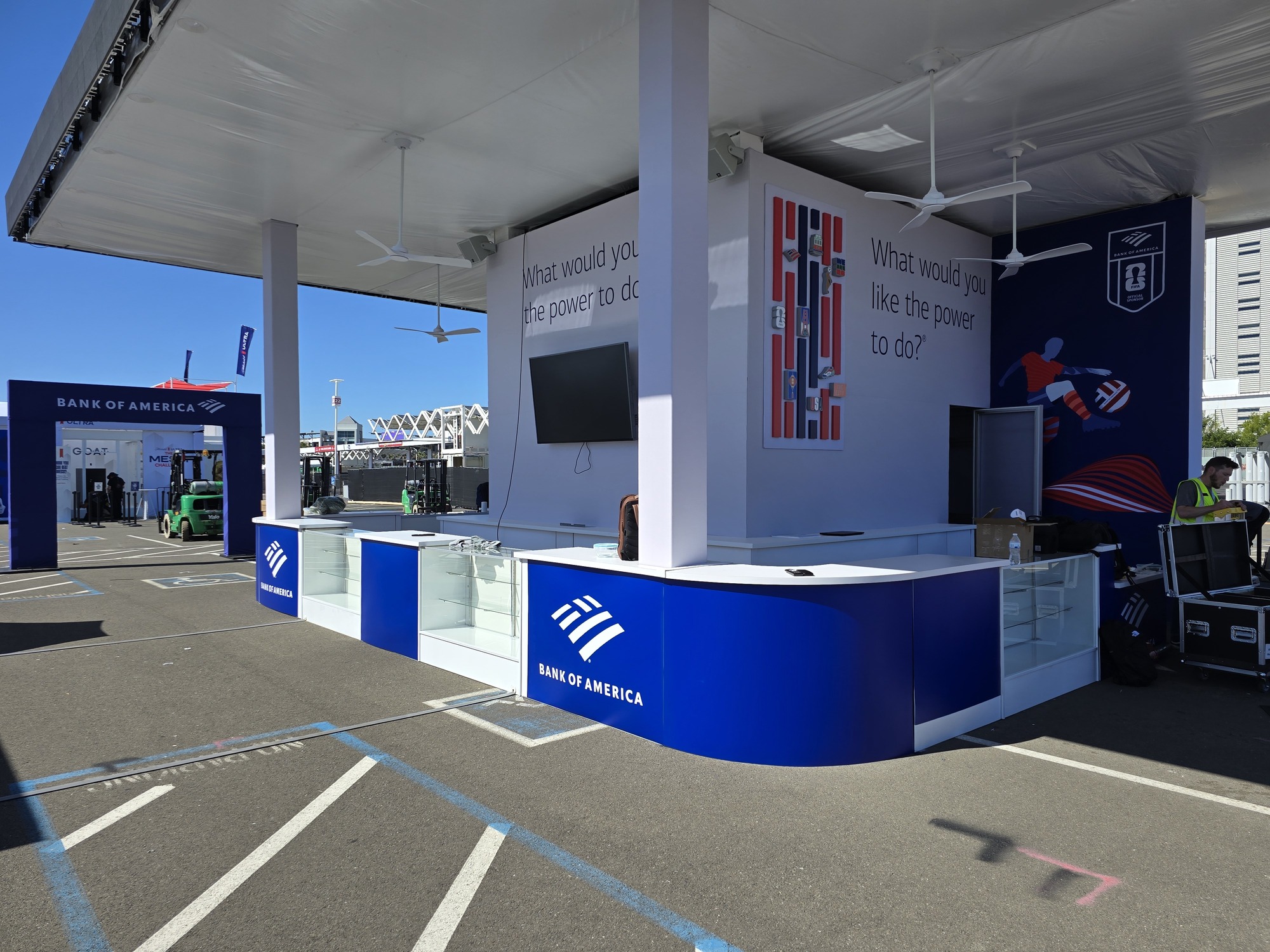 Interior view of the Bank of America experiential exhibit with custom counters, branded graphics, digital displays, and a covered hospitality space.