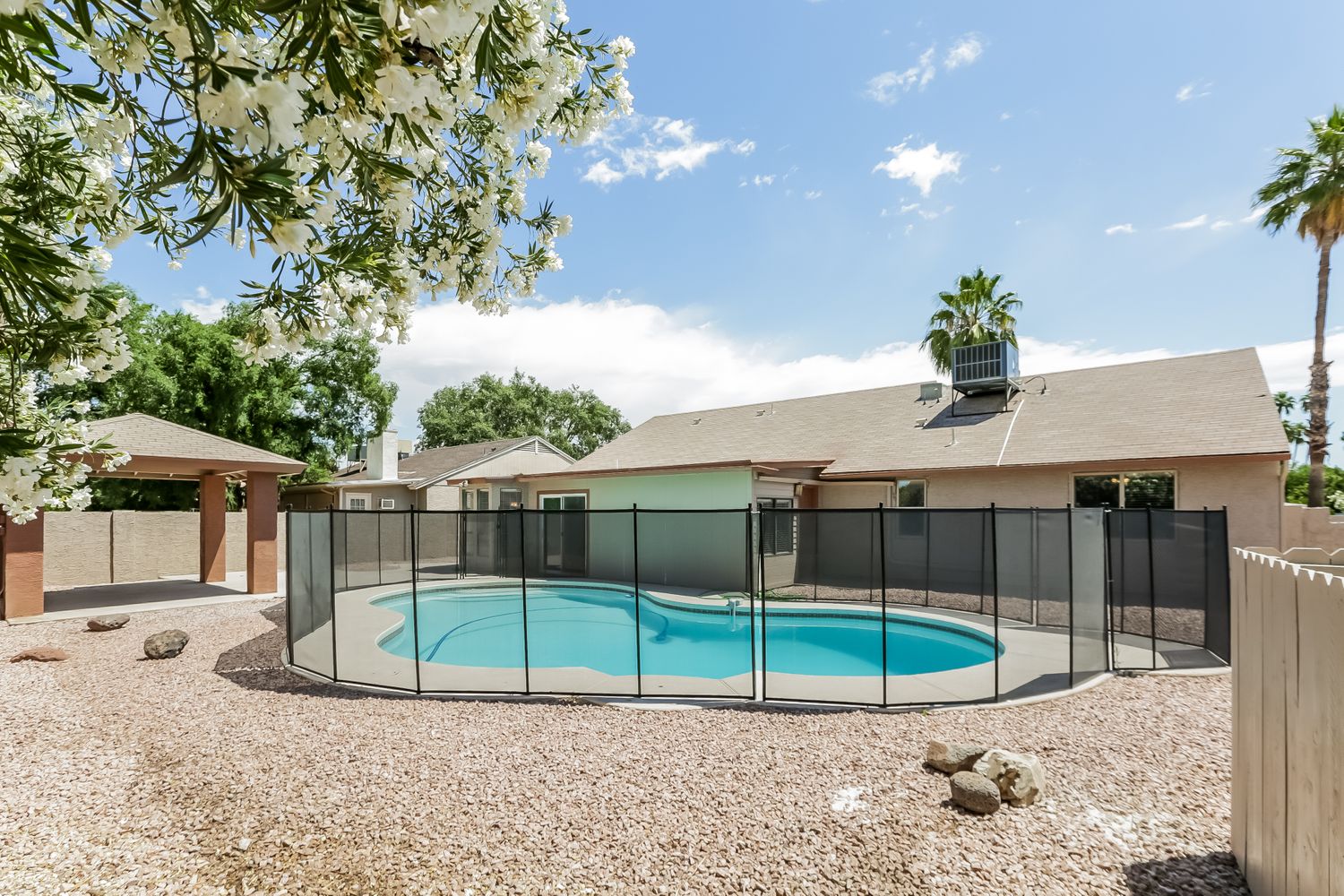 Fenced backyard with a sparkling pool and patio at Invitation Homes Phoenix.