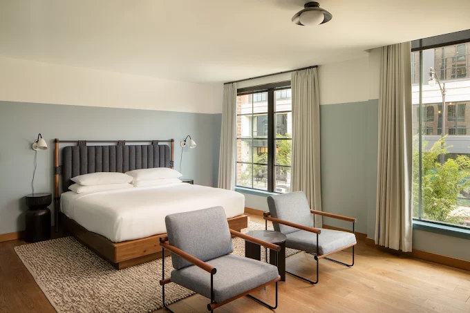 A king guest room at The Junto, with large windows overlooking Franklinton. 