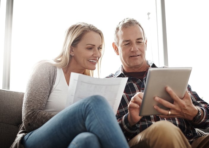 A couple reviewing documents on their tablet.