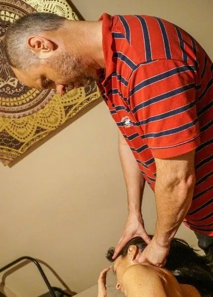 Therapist performing therapeutic neck and upper body treatment using specialized manual techniques t 
