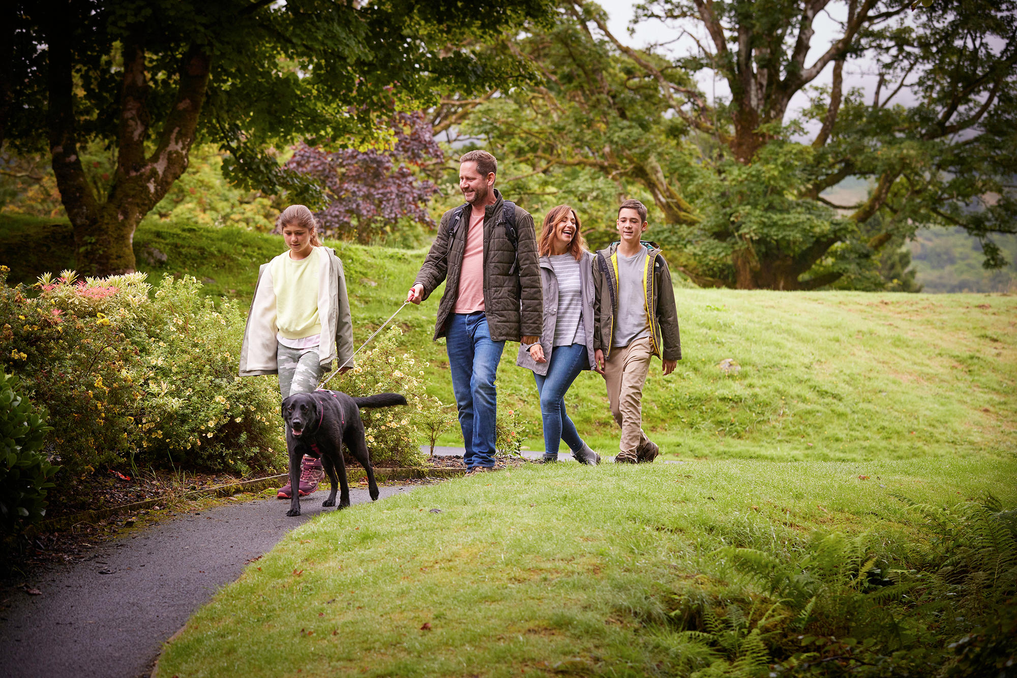 Family take a stroll with their dog through the grounds of Drimsynie Estate