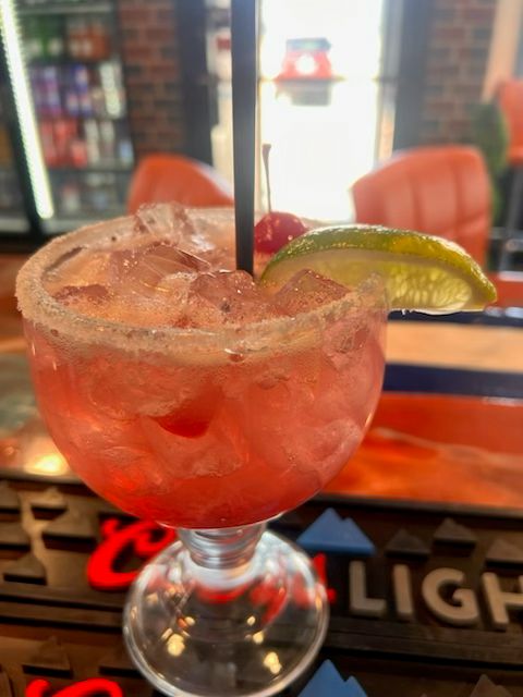 Refreshing fruit margarita served on the rocks with a lime wedge and salted rim at Catramex Restaurant.