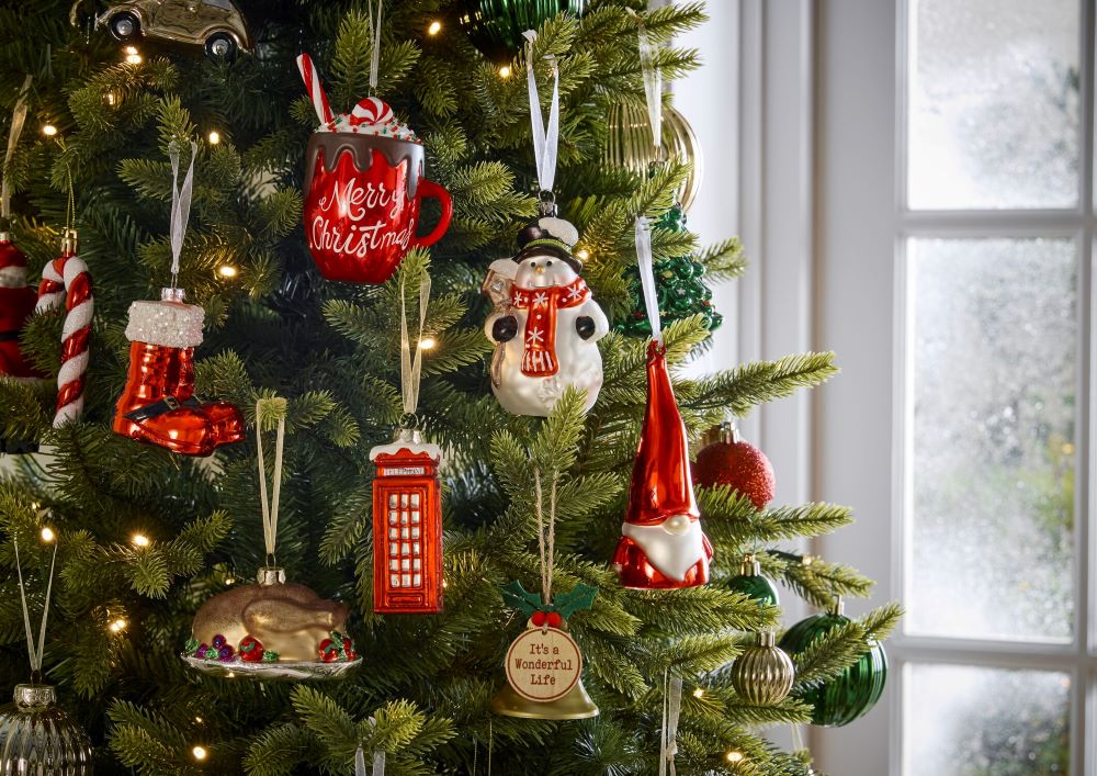 A green pre lit Christmas Tree decorated with a range of red and white baubles