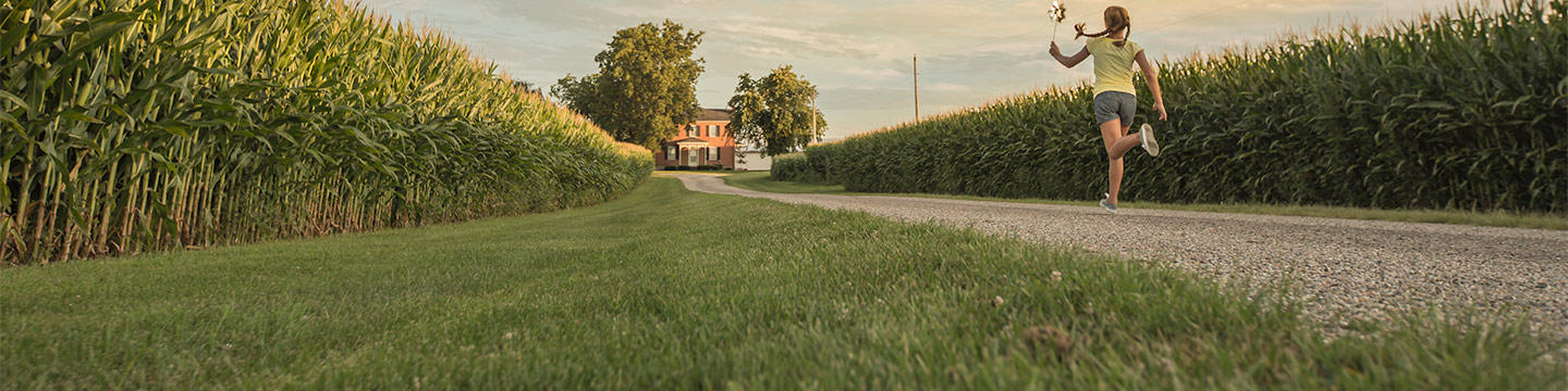 Girl running to house by the cornfields