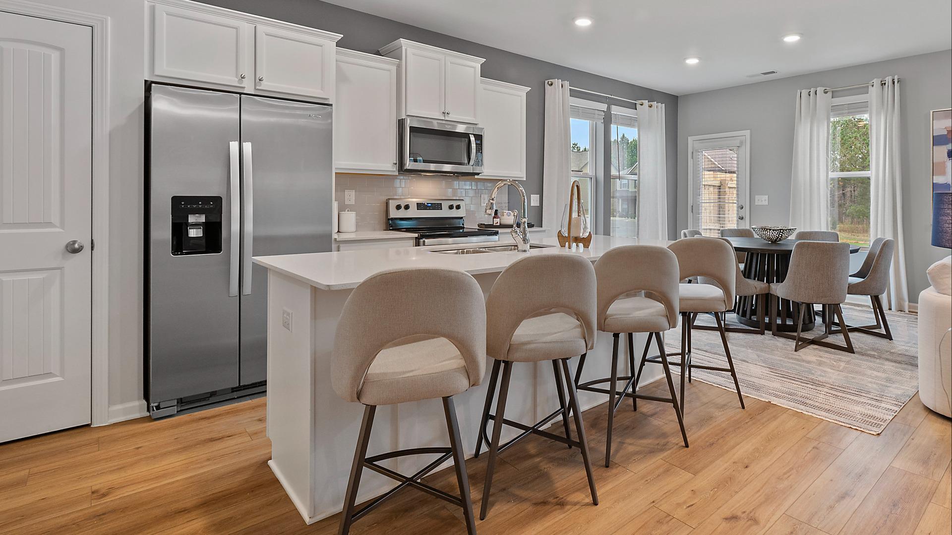 Gourmet kitchen with white cabinets and island at DRB Homes The Borough at Wyndham South