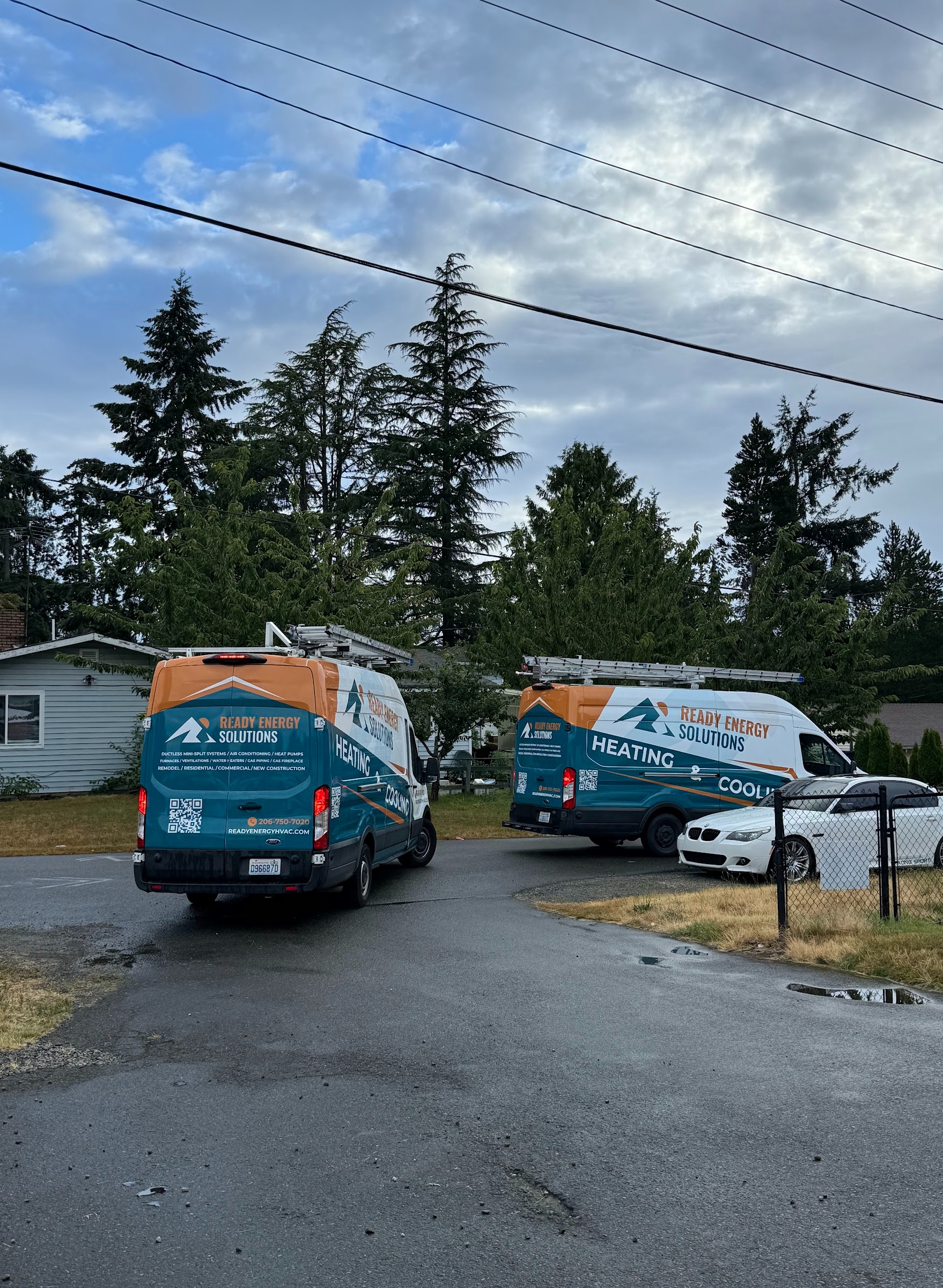 Two Ready Energy Solutions heating and cooling service vans at a job site. Local HVAC contractor serving Seattle and Bellevue, south through Renton and Kent to Federal Way.