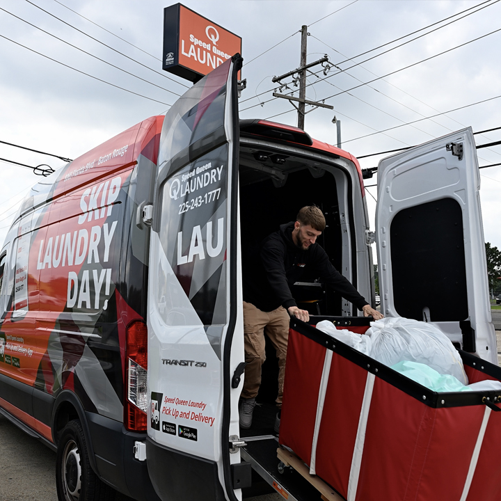 Speed Queen Laundry Pick Up and Delivery service van being loaded with laundry, offering customers a 